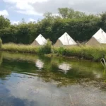 Bell Tents set out around a lake in South Cerney, near Cirencester