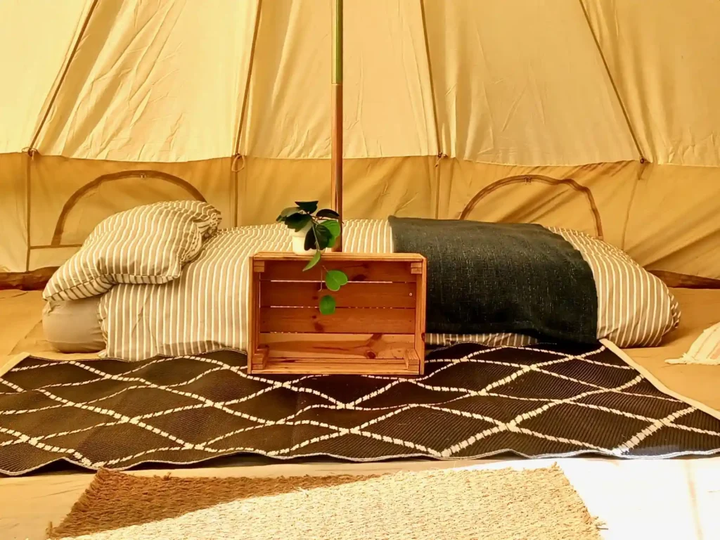 Cosy bell tent interior with bedding.